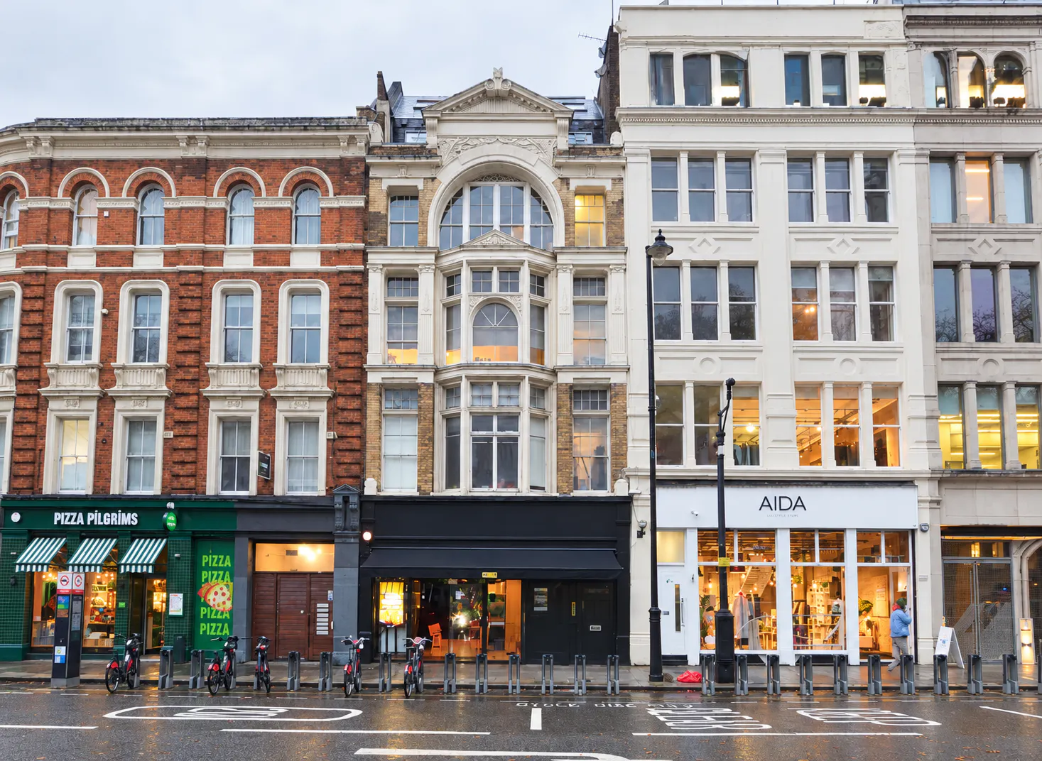Ground Floor and Basement, 134 Shoreditch High Street, London, Retail To Let - Rainy Victorian City Block with Warm Storefronts.png - More details and enquiries about this property